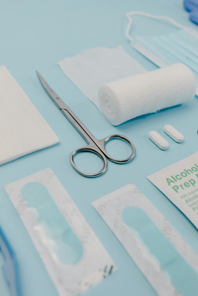 Close-up of medical supplies on a blue background, featuring bandages, pills, and scissors.